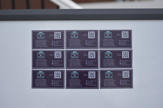 Nine custom magnetic business cards displayed on a metal surface — bulk magnetic business card order by Snap'N'Stick