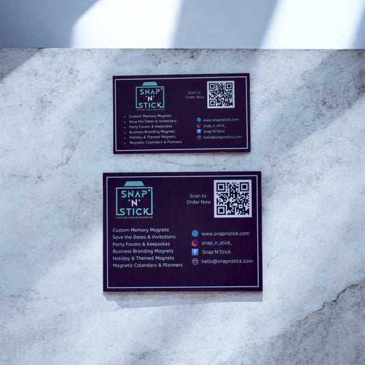 Snap'N'Stick custom magnetic business cards with QR code and logo on a marble surface